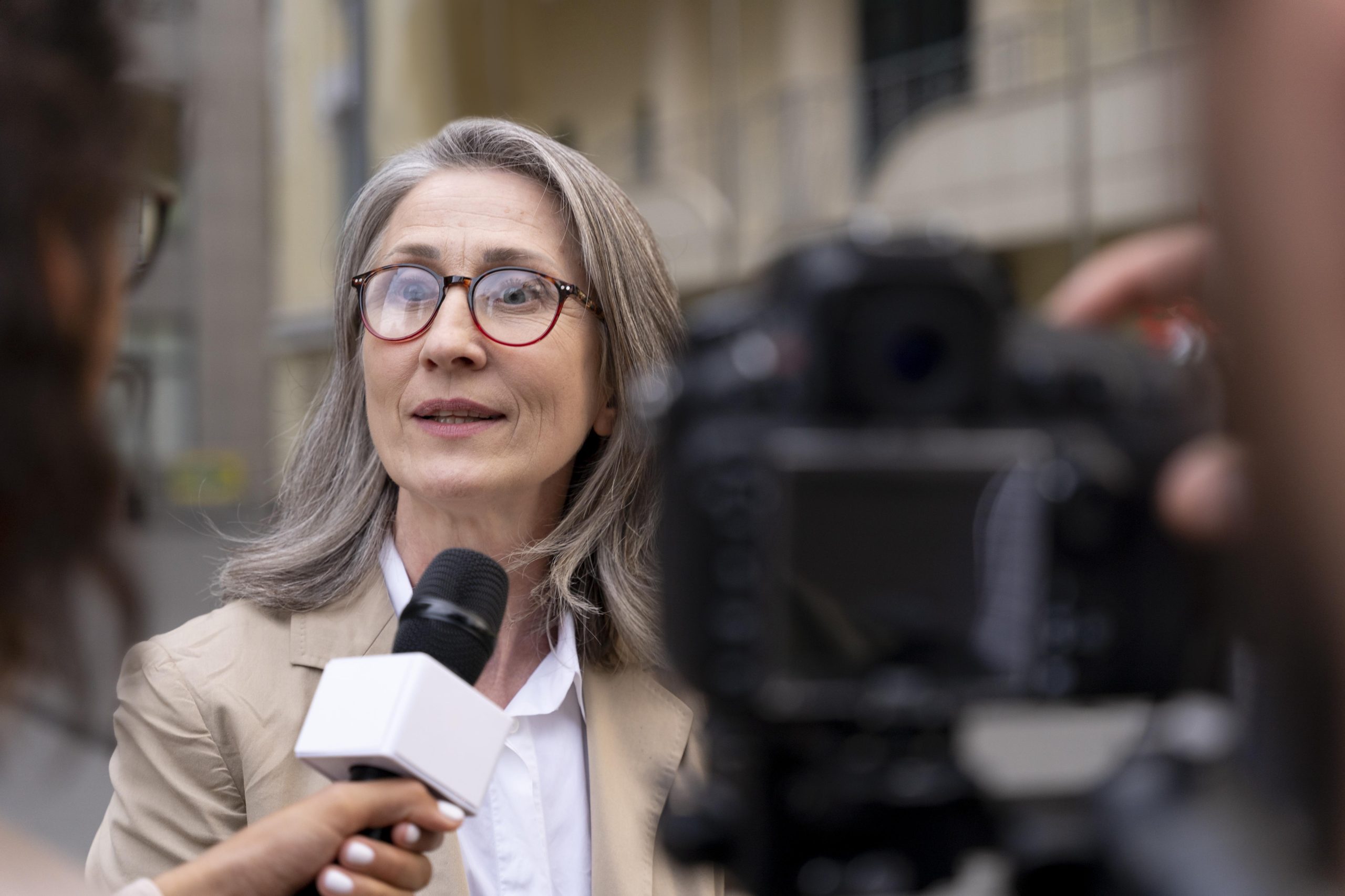 female journalist taking interview her cameraman scaled